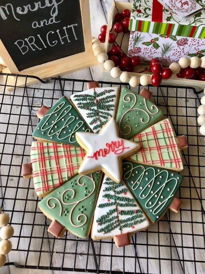 decorated christmas cookies on a cooling rack next to a chalk board and other holiday decorations