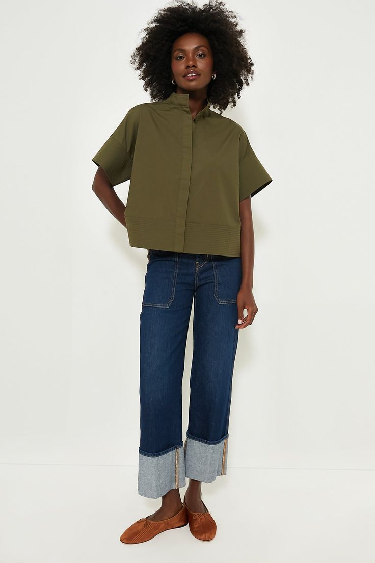 The Olive Green Sofia Shirt is the elevated style staple your closet needs. A short sleeve button down with a slightly cropped hem and a boxy silhouette that's perfect for pairing with all kinds of bottoms, this style is finished with trapunto stitching that adds an extra-special detail to a classic look. Style with trousers and flats for the office, with a skirt and kitten heels for a dinner date, or with denim and crisp sneakers for weekend wear — this number can do it all. Stand collar Droppe Spring Boxy Workwear Tops, Trendy Cropped Shirt For Spring, Spring Boxy Tops For Workwear, Short Sleeve Cropped Shirt With Button Closure For Spring, Casual Cropped Shirt With Button Closure, Trendy Boxy Cropped Shirt With Short Sleeves, Casual Relaxed Fit Cropped Shirt, Modern Cropped Shirt For Spring, Modern Short Sleeve Spring Work Shirt