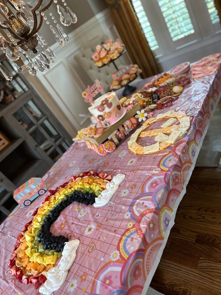 a table topped with lots of cakes and cupcakes next to a chandelier