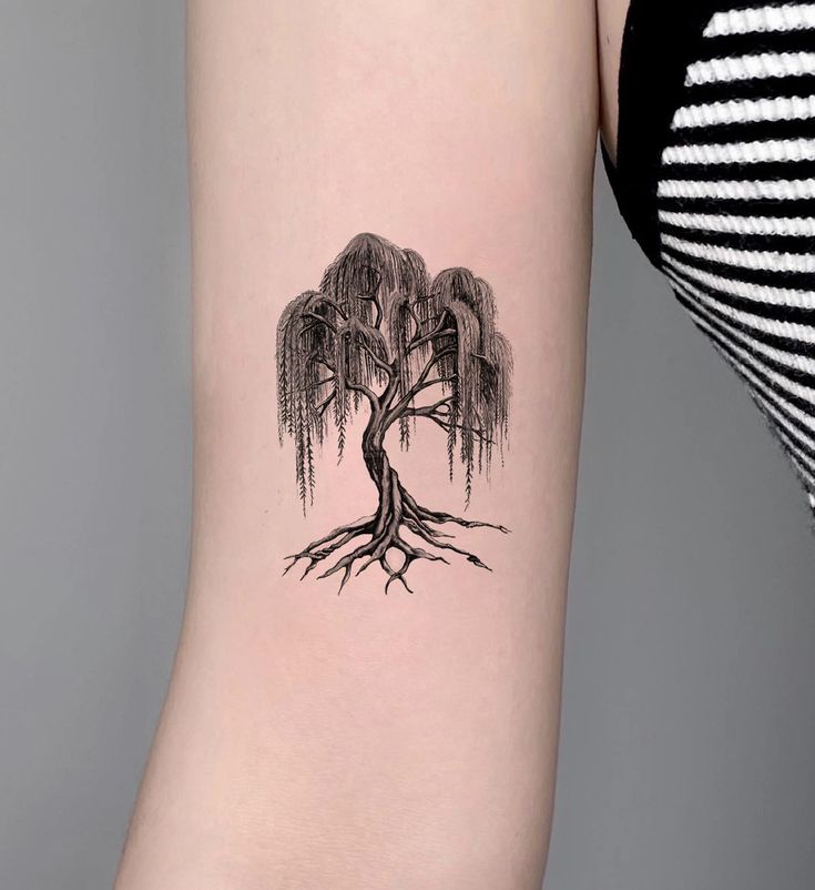 a woman's arm with a tree tattoo on the left side of her body