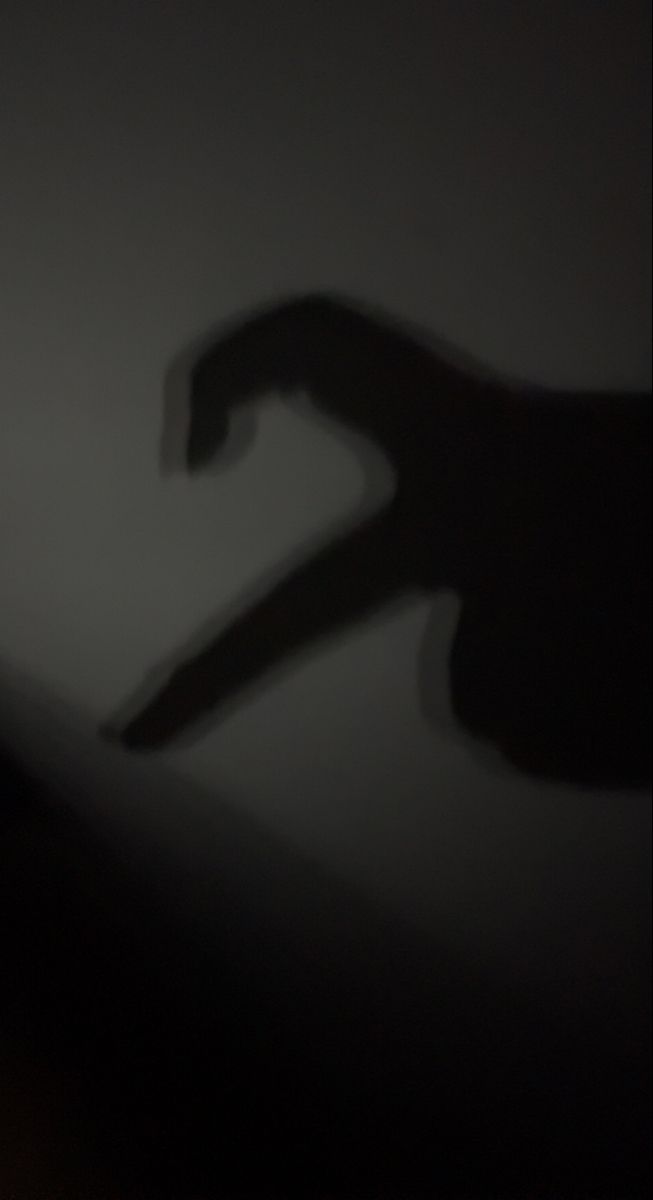 the shadow of a person's hand holding a knife