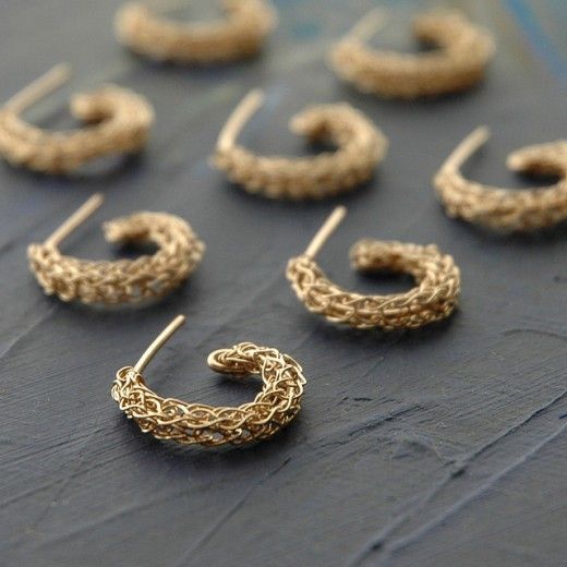 six pairs of gold hoop earrings sitting on top of a table