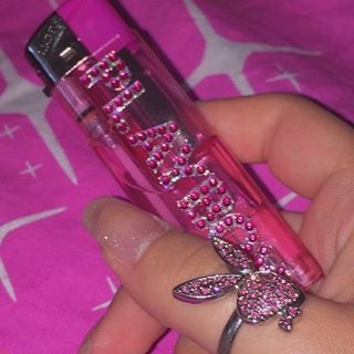 a person holding a pink perfume bottle with a dragonfly on it's side