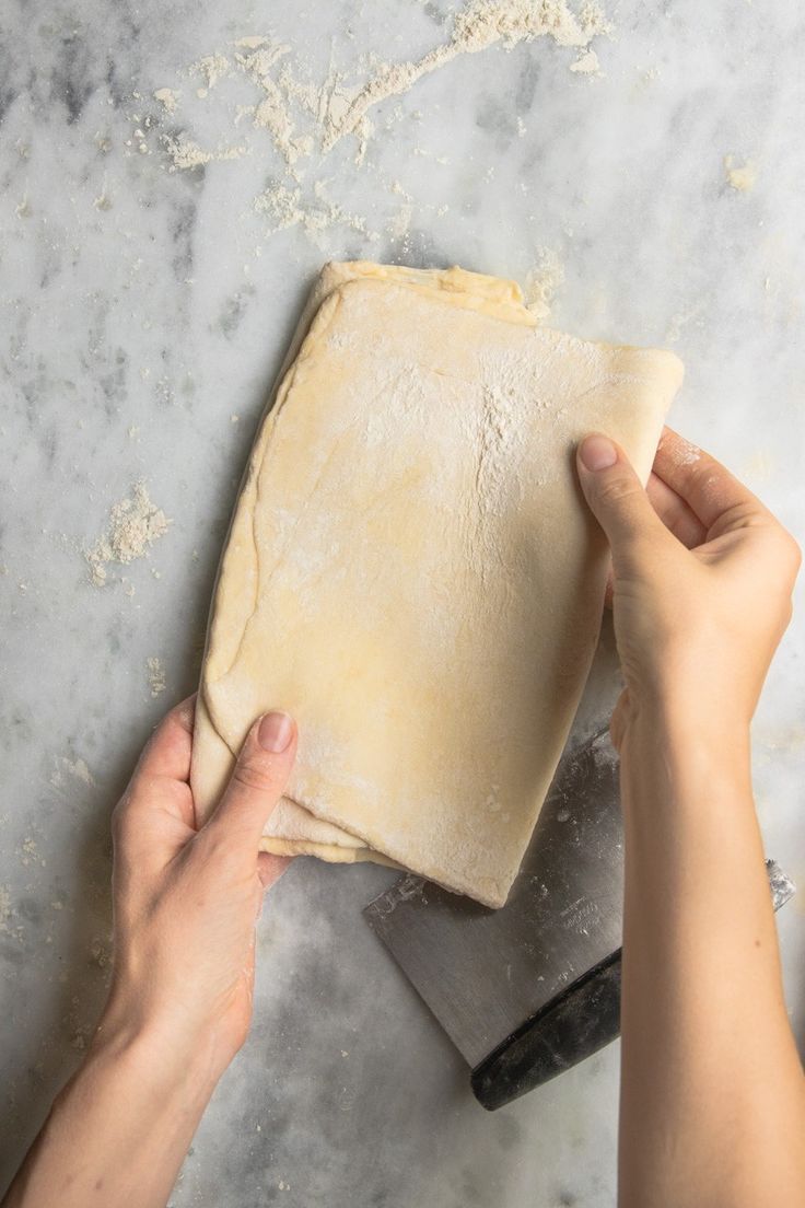 a person is kneading dough on top of a table