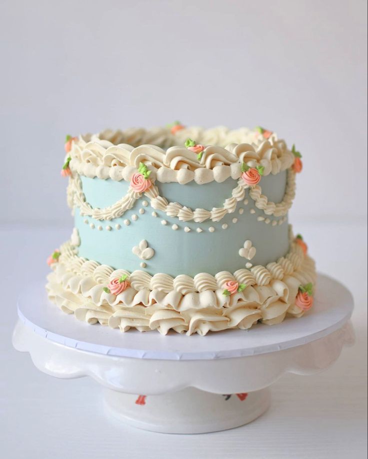 a three tiered cake sitting on top of a white plate covered in frosting