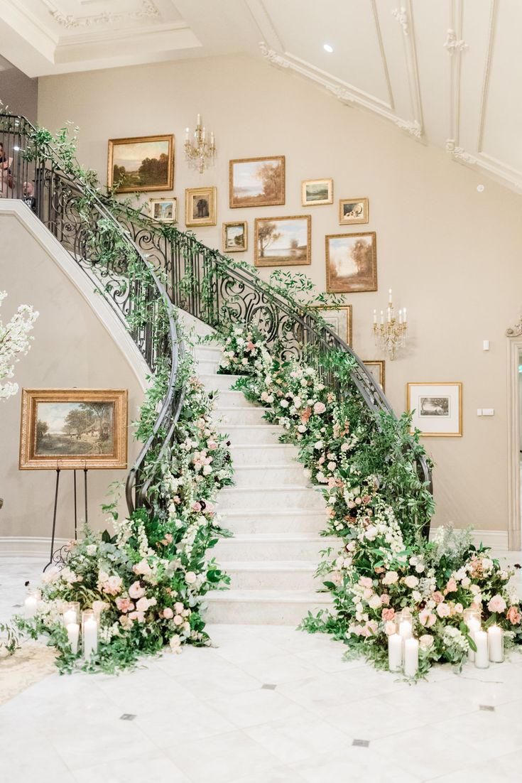 an elegant staircase decorated with greenery and flowers