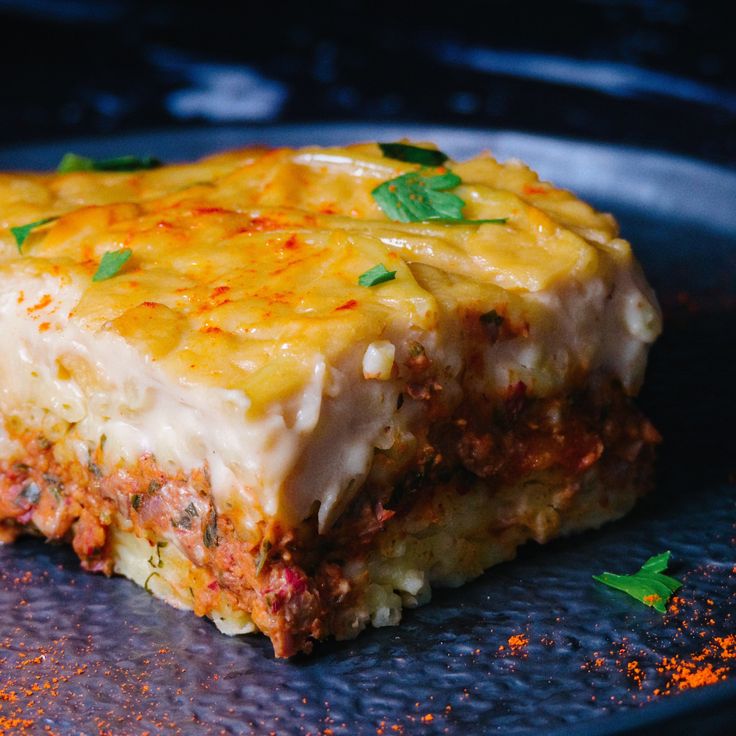 a piece of lasagna sitting on top of a pan covered in cheese and sauce