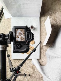 a camera sitting on top of a tripod next to a bowl of oatmeal