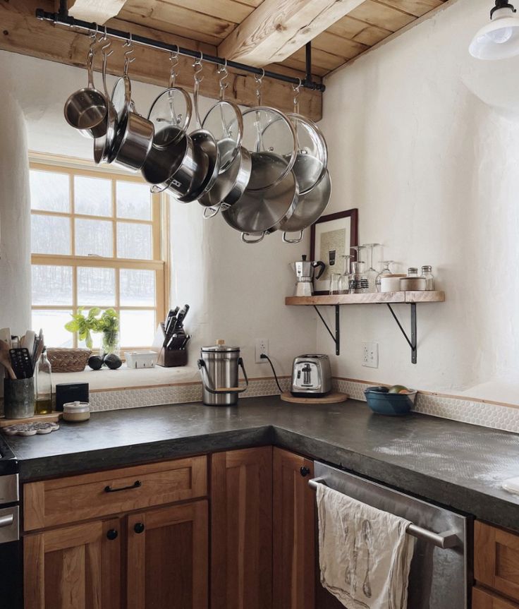 pots and pans hanging from the ceiling in a kitchen