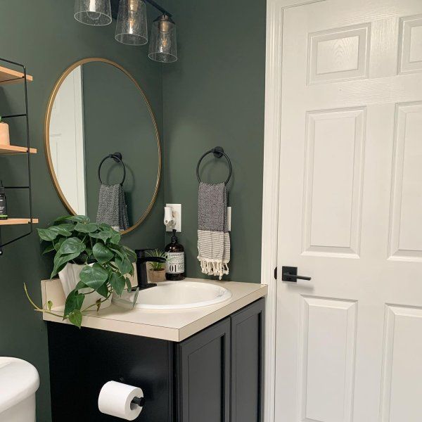 a white toilet sitting next to a sink in a bathroom under a mirror and lights