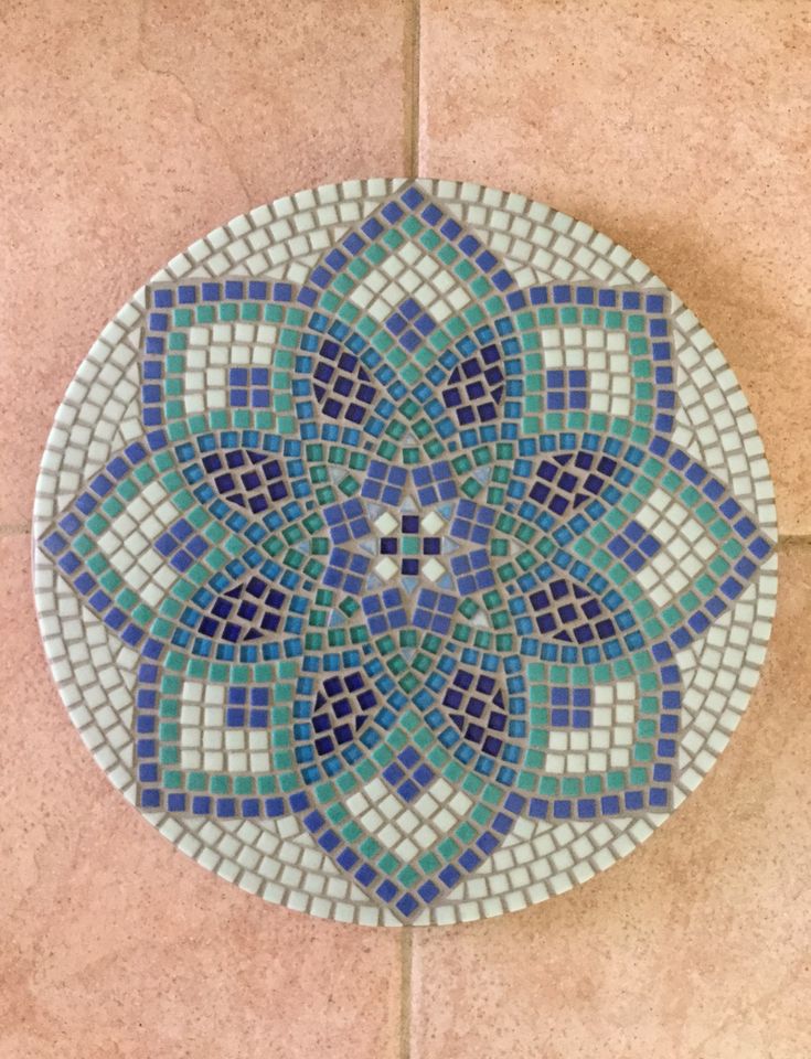 a blue and green mosaic tile design on the floor