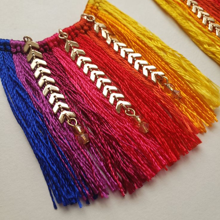 four different colored tassels on a white surface