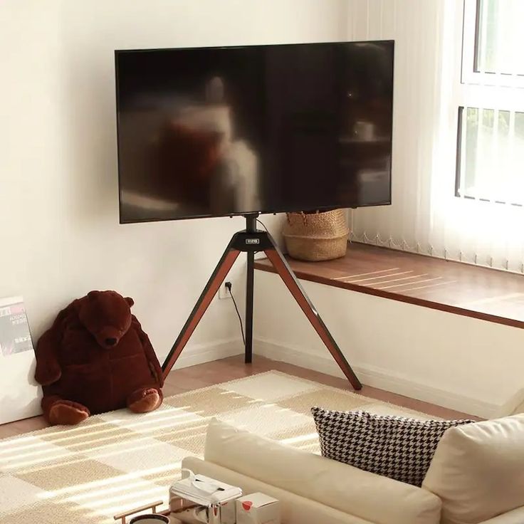 a large flat screen tv sitting on top of a wooden stand in a living room