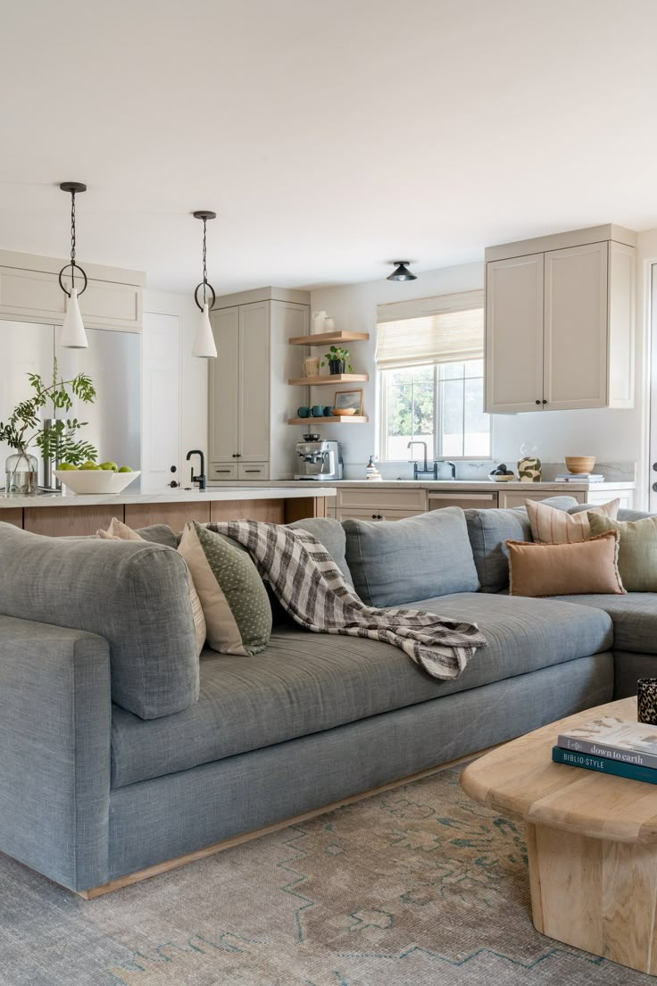 a living room filled with furniture next to a kitchen