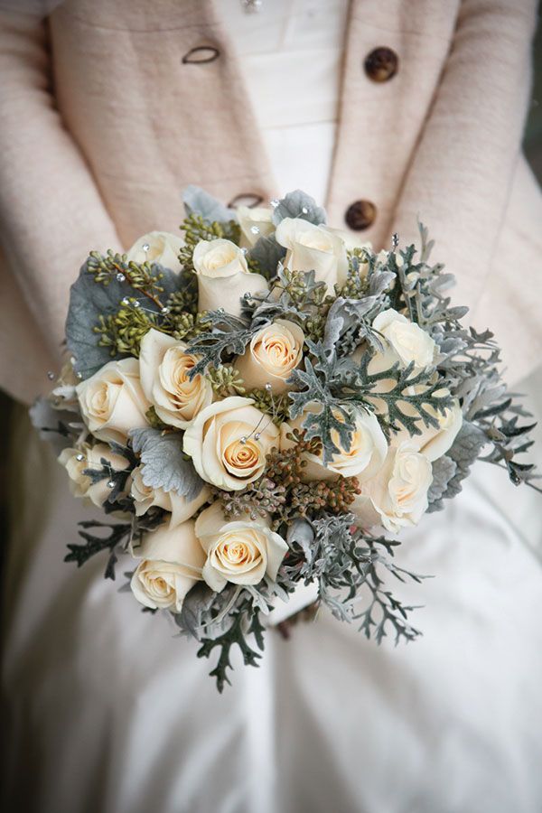 a bridal holding a bouquet of white roses