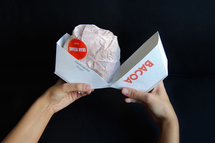 two hands holding up a piece of paper that has been wrapped in foil with the word bwccow on it