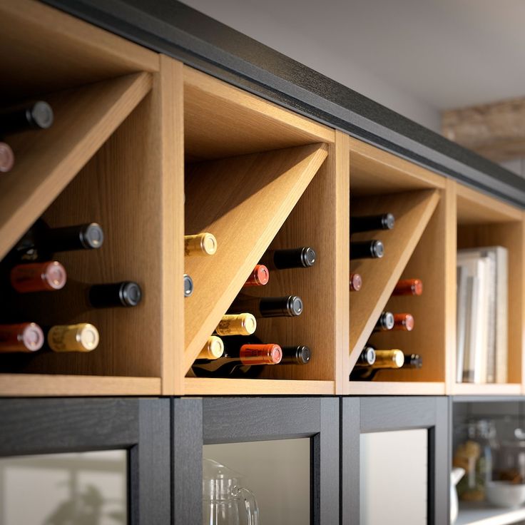 the wine bottles are lined up on the wall behind the cabinets in the room that is filled with glasses