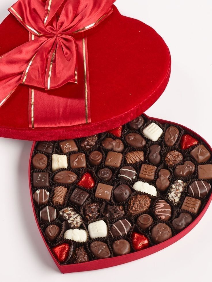 two heart shaped boxes filled with assorted chocolates