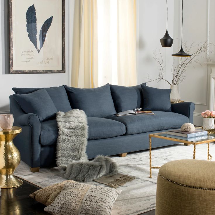 a living room with blue couches and rugs in front of the fireplace,