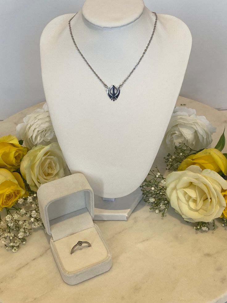 Shop our iconic 18k Silver Fateh necklace and dainty Fateh ring as a matching set. Both pieces symbolise the sikh symbol - the Khanda and are constructed from stainless steel making them lightweight, tarnish-free and water-resistant. The necklace is a unisex piece that can be adjusted to suit your style, whether that is a choker necklace or as a lengthened chain. This has a chain length of 34cm + 8cm extender so can be worn how you prefer. Polished Oval Pendant Jewelry For Wedding, White Gold Polished Teardrop Pendant Jewelry, Elegant Oval Pendant Stainless Steel Jewelry, Polished Finish Oval Pendant Jewelry For Wedding, Elegant Stainless Steel Oval Pendant Jewelry, Elegant Oval Stainless Steel Pendant, Tarnish Resistant Silver Teardrop Jewelry, Silver Diamond Cut Jewelry Sets Gift, Elegant Stainless Steel Jewelry As Gift For Her