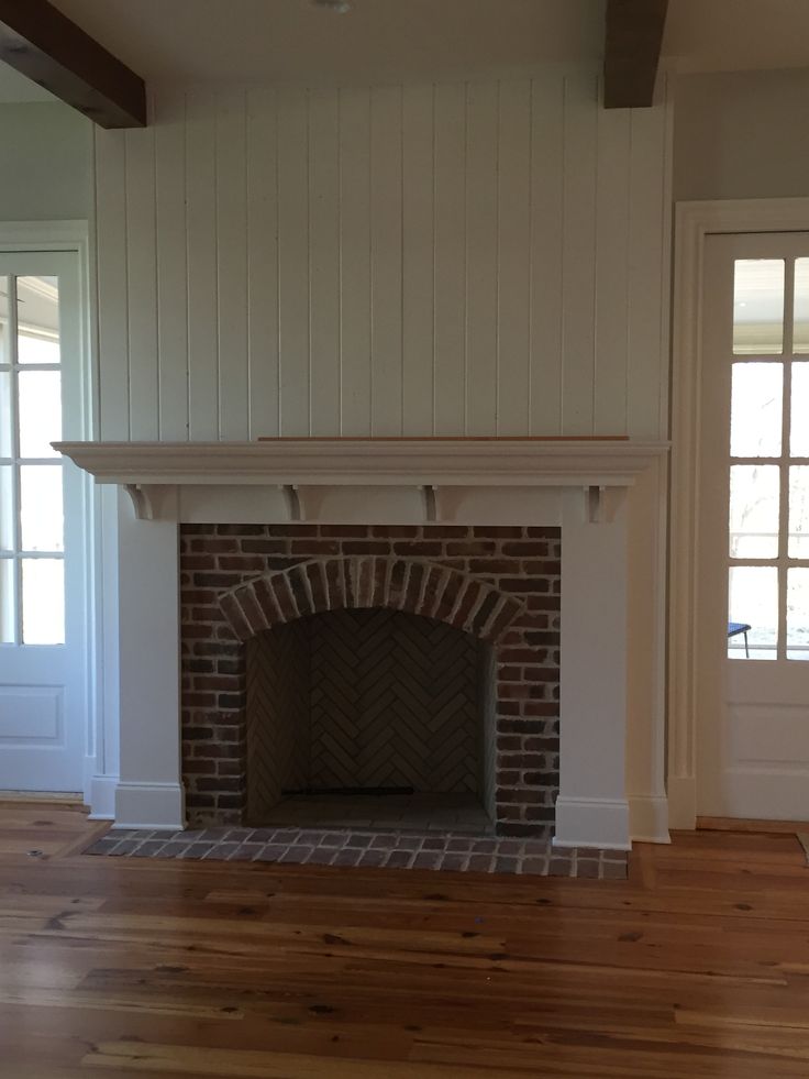 an empty living room with a brick fireplace