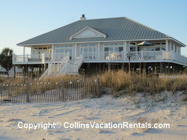 a house on the beach with stairs leading up to it