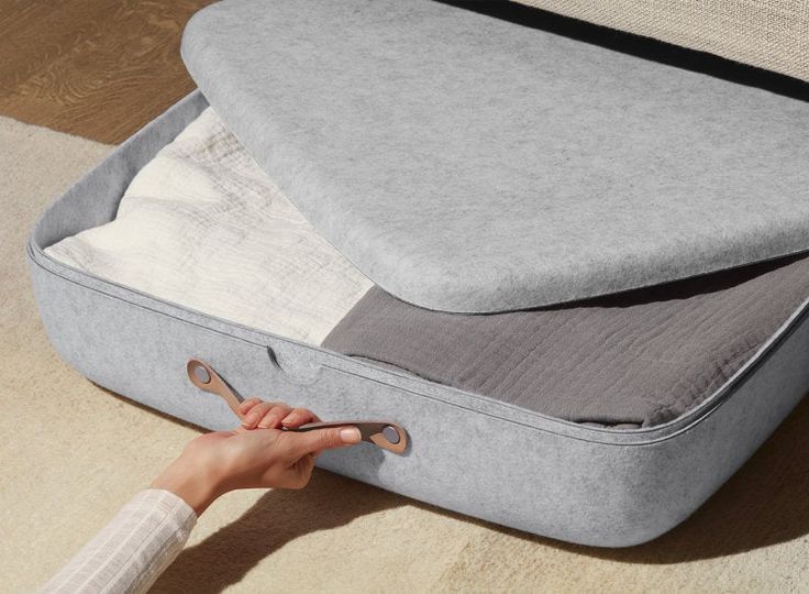 a person is holding onto the bottom of a suitcase with its lid open and it's handle extended