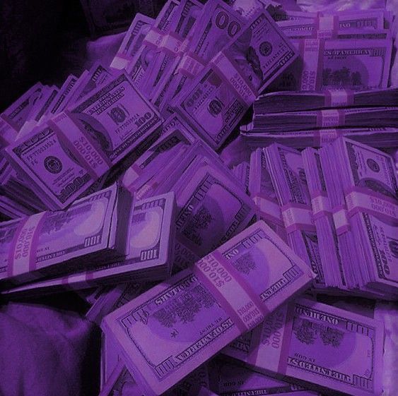 a pile of twenty dollar bills sitting on top of a purple cloth covered tablecloth