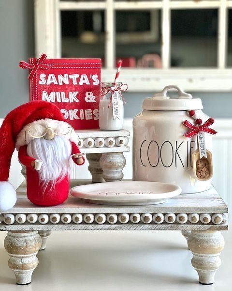 a santa's milk and cookies sign is sitting on a table next to a cookie jar