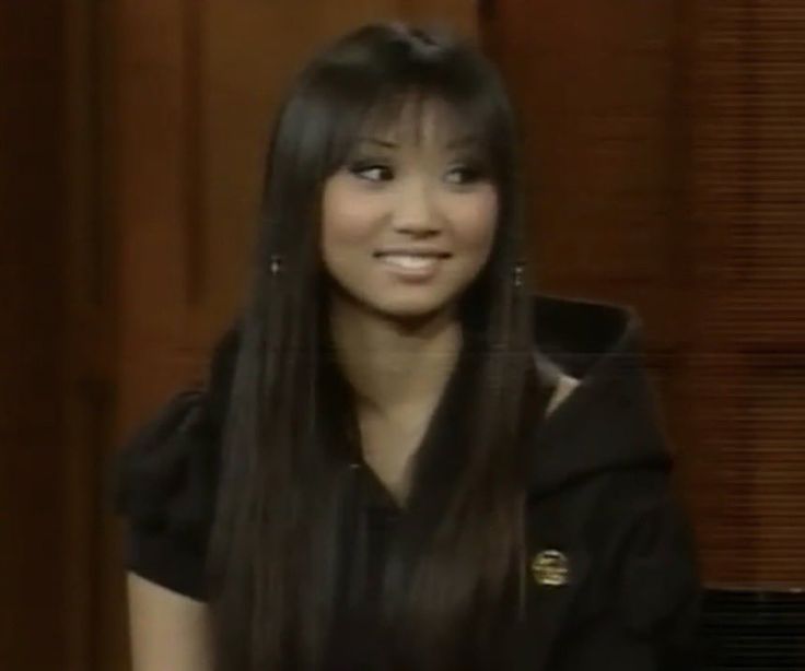 a woman with long black hair sitting down