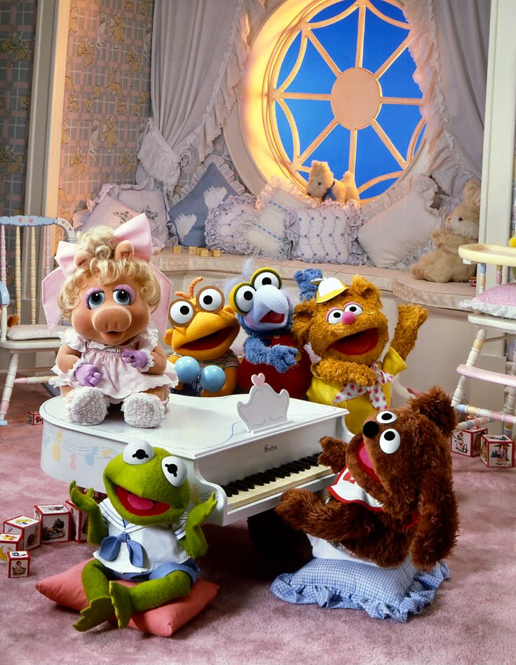 the muppets are posing for a photo in front of a piano and other stuffed animals