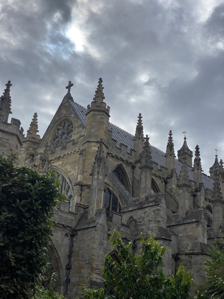 an old building with many windows and spires on the top, under a cloudy sky