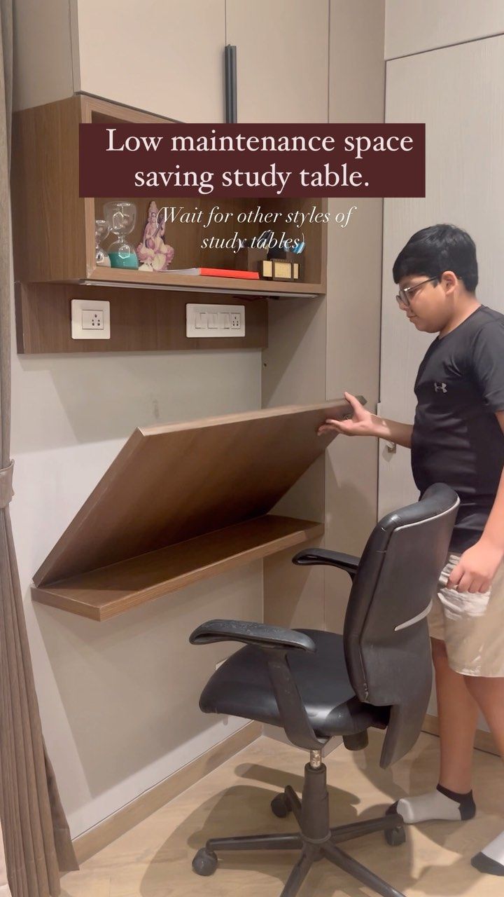 a boy standing next to a desk with a chair on it