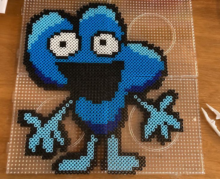 an image of a blue cartoon character made out of perler beads on a table