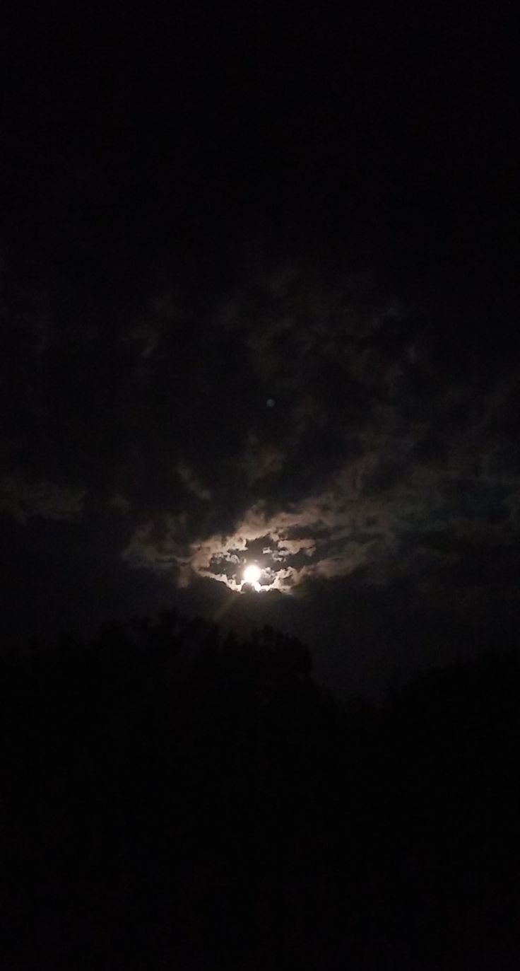 the moon is shining brightly in the dark sky