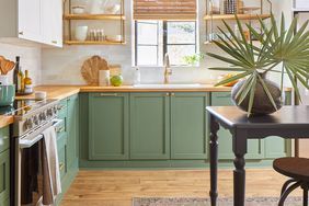 a kitchen with green cabinets and wooden floors