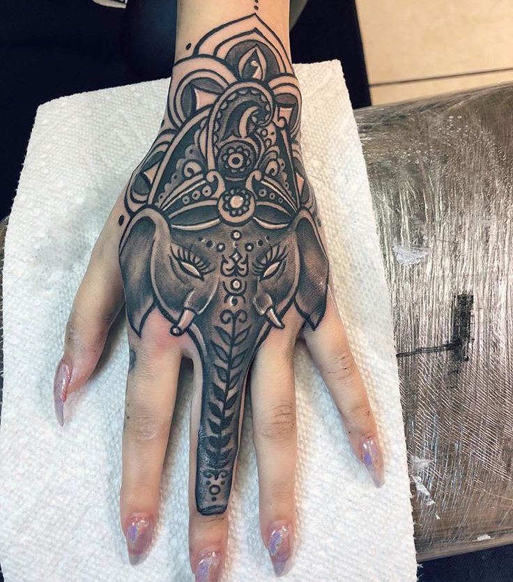 a woman's hand with an elephant tattoo on it