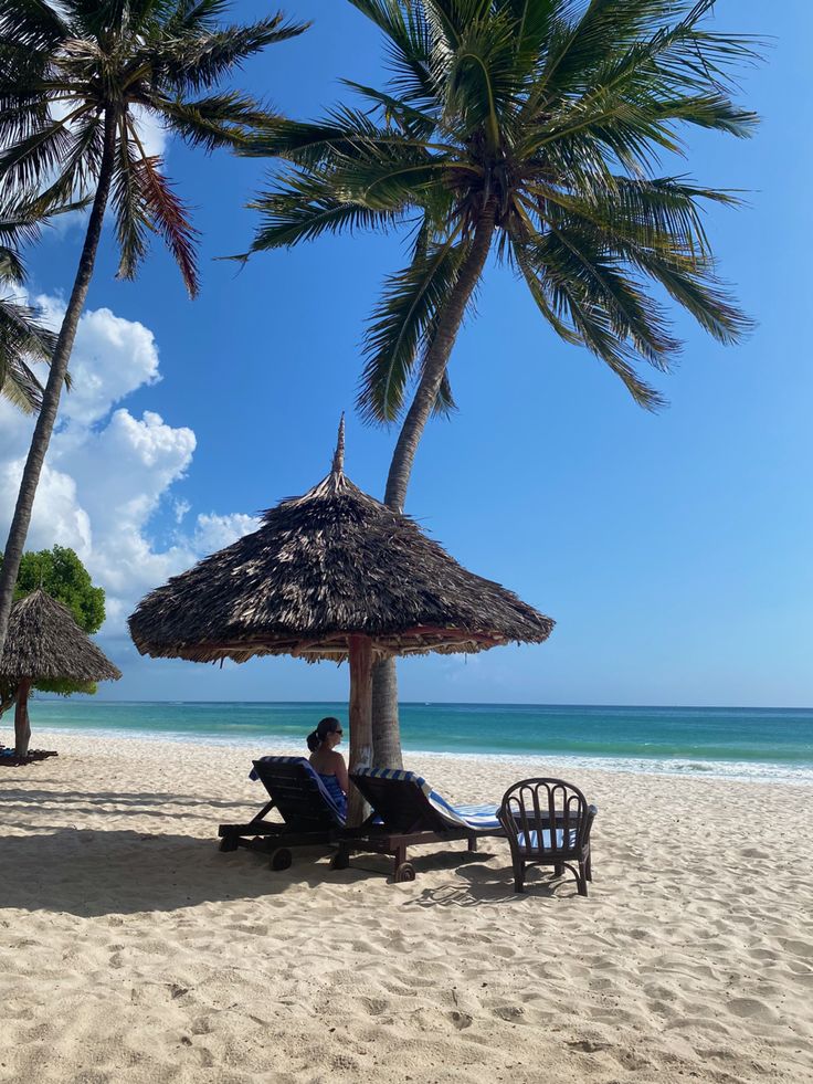 a person sitting under an umbrella on the beach