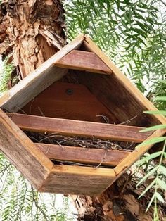 a wooden birdhouse hanging from a tree