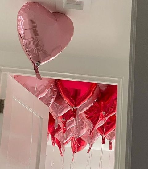 heart shaped balloons are hanging from the ceiling