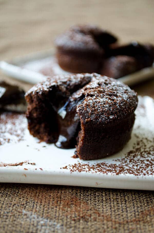 chocolate cupcakes on a white plate sitting on a table