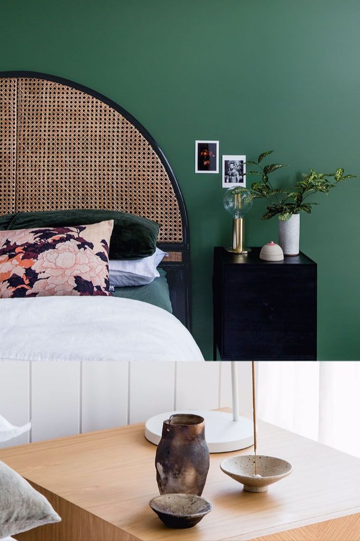 a bed sitting next to a wooden table with two vases on top of it