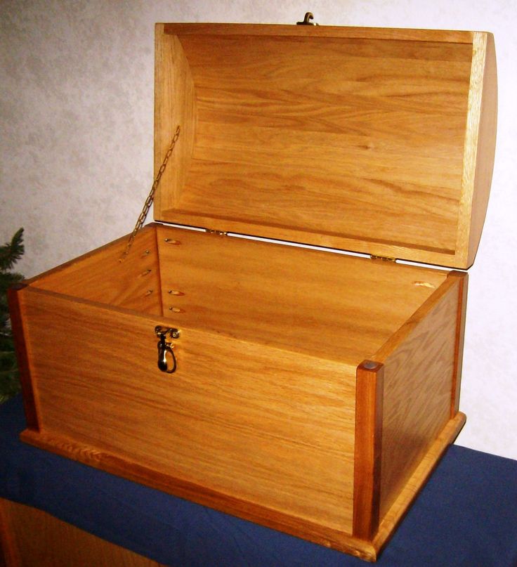 an open wooden box sitting on top of a blue blanket next to a christmas tree