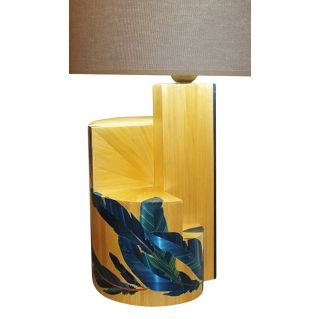 a lamp that is on top of a wooden table next to a light with a blue and green leaf design