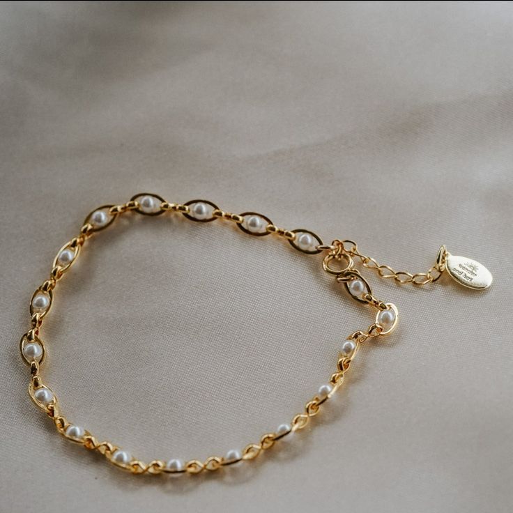 Our Pippa Pearl Bracelet is dainty + modern! What do we love about it? The tiny pearl accents add just a touch of traditional style in a modern way! This bracelet is perfect for any bridal event but can also be worn any time of the year or for any occasion which makes this the perfect gift! BRACELET FEATURES Materials: Brass, 14K Gold, Rhodium, Faux Pearl Finish: Choice of Yellow Gold or Rhodium Plating Dimensions: 6.5" with a 2" extender (can be worn up to 8.5") 14K gold-filled or sterling silv Elegant Pearl Charm Bracelet, White Metal Bracelets With Pearl Drop, White Metal Bracelet With Pearl Drop, Elegant Metal Chain Bracelet With Pearl, Minimalist Charm Bracelet For Wedding, Elegant Metal Bracelets With Pearl Chain, Elegant Metal Bracelet With Pearl Chain, Elegant Silver Beaded Bracelets With Delicate Chain, Delicate Pearl Charm Bracelet For Formal Occasions