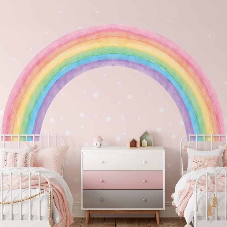 a bedroom with two beds and a rainbow painted on the wall