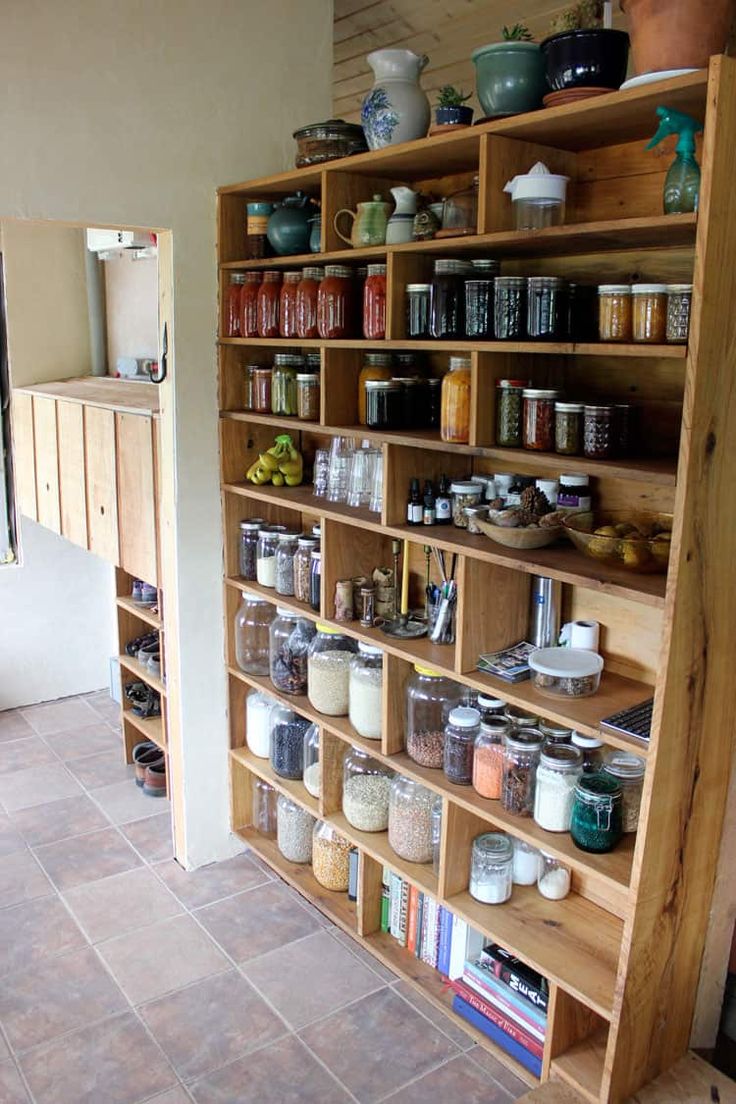 a wooden shelf filled with lots of jars and containers