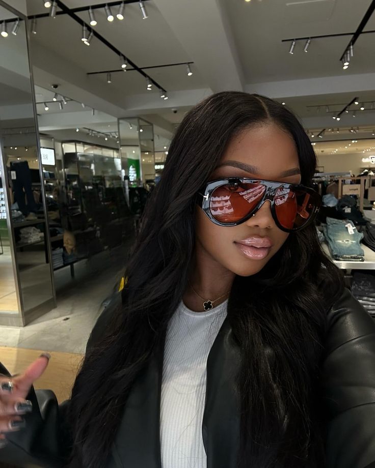 a woman wearing sunglasses in a car showroom