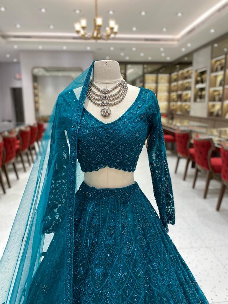 This Teal Bridal Lehenga BL-099 offers a stunning and elegant look for any bride's special day. Made with high-quality materials, it provides comfort and durability. The rich teal color adds a regal touch while the intricate design showcases traditional craftsmanship. Perfect for capturing unforgettable moments. Fabric: Net with Satin Silk Lining! WASH CARE INSTRUCTIONS - Please Dry clean only when it is applicable! Ready to Ship! Teal Bridal Lehenga, Net Lehenga Designs Latest Bridal, Pretty Lehengas, Teal Blue Lehenga, Teal Lehenga, Turquoise Semi-stitched Choli For Wedding, Turquoise Bollywood Choli For Wedding, Turquoise Zari Work Wedding Dress, Bollywood Style Turquoise Choli For Wedding