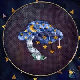 a cross stitch picture of a blue mushroom with stars